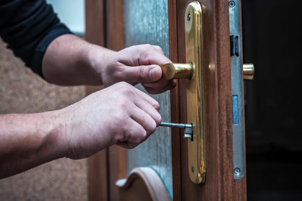 A residential locksmith repairs a door.